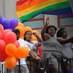 同志游行的参与者在花车上带着气球和彩虹