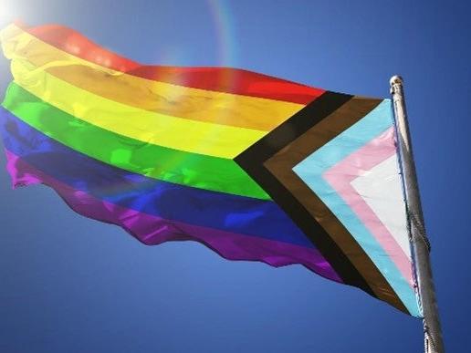 A Pride flag waves in the wind.