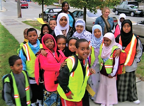 贝利·加泽特学校学生成群结队地步行上学、家长轮流带队(步行校车)。
