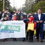 The SPS superintendent and mayor walk with students who are carrying a sign.